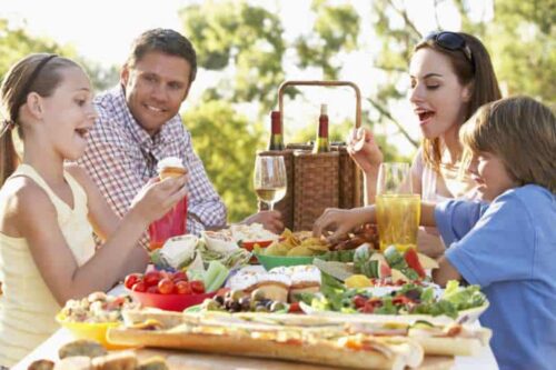 A Family enjoying a gift hamper at a picnic.